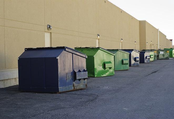 a construction worker empties a wheelbarrow of waste into the dumpster in Bellaire TX